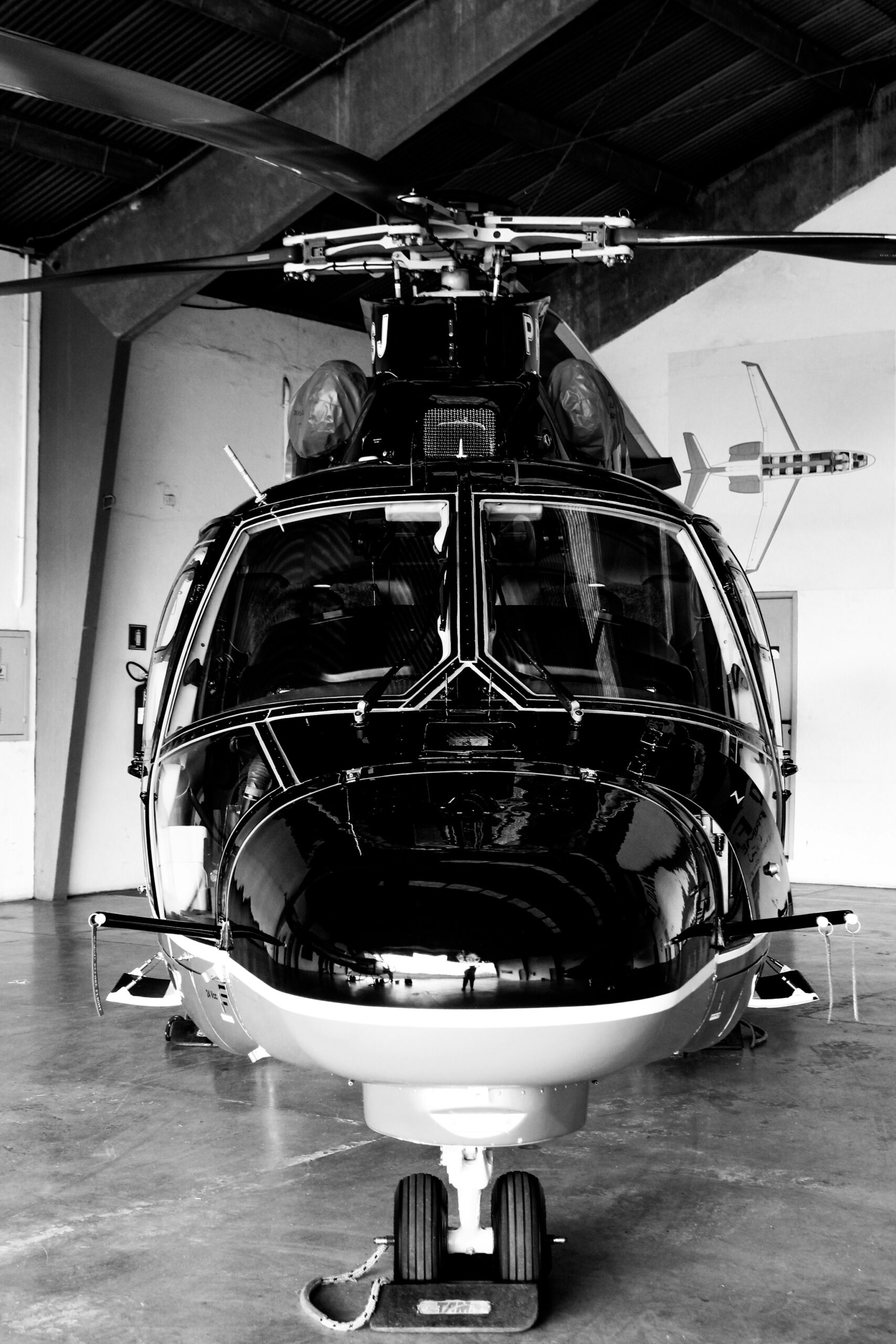 a black and white photo of a helicopter in a hangar